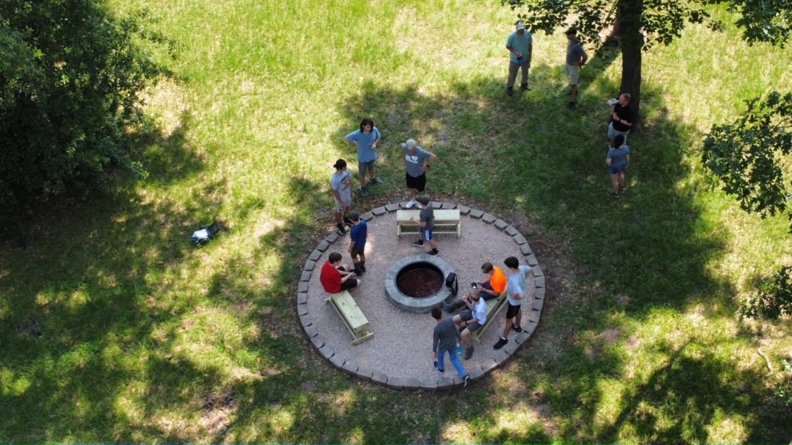 Aerial view of Scouts gathering around a campfire circle